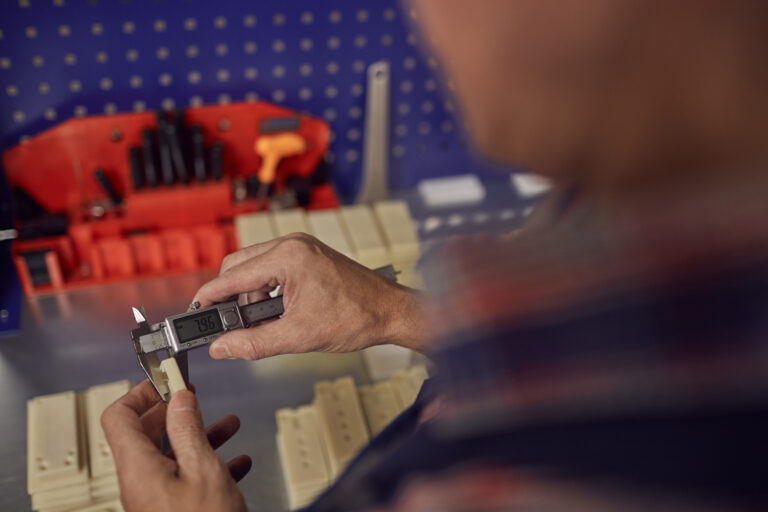 Engineer measuring a moulded plastic part with a vernier caliper