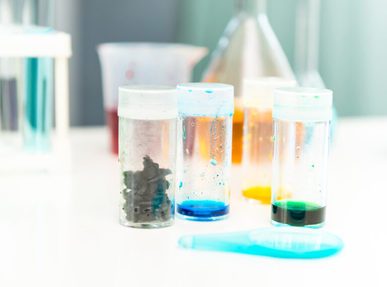 Plastic samples in laboratory containers for chemical resistance testing